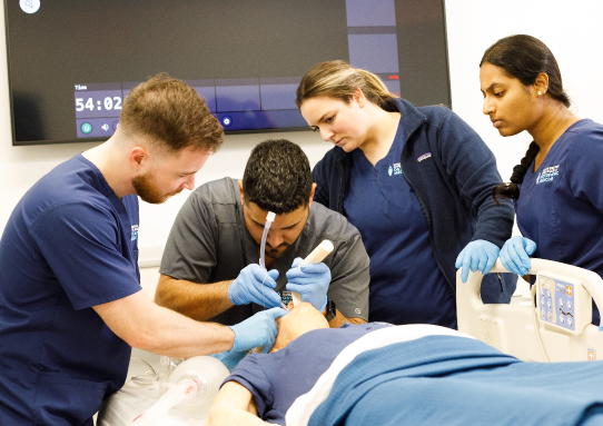 A KansasCOM student practicing a procedure on a dummy